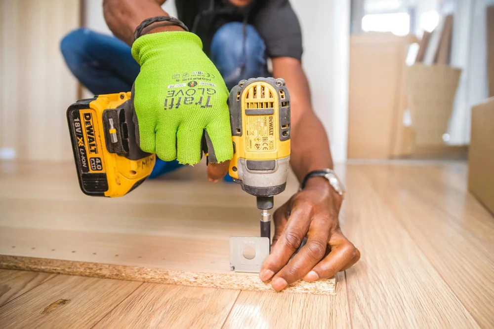 Menuisier assemblant un meuble en panneau bois